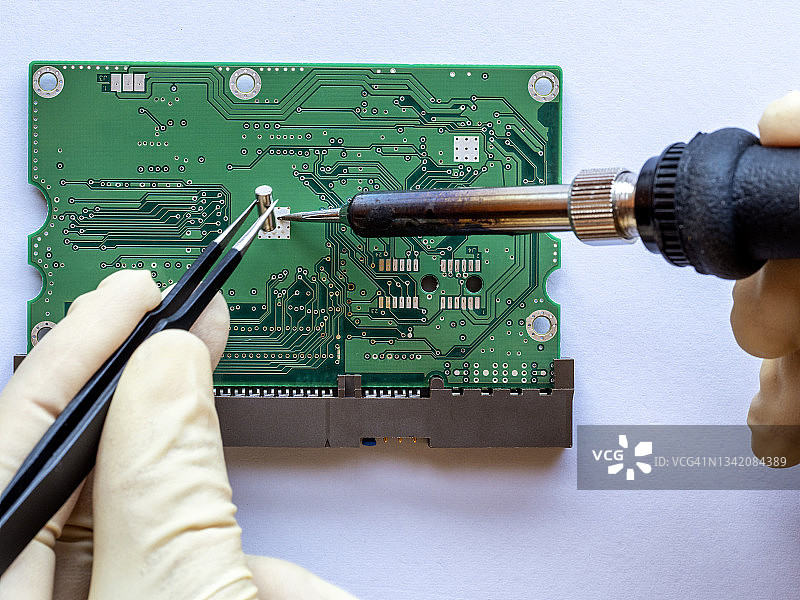 技术员在电子维修车间的工作台上焊接电子元件线路板。图片素材