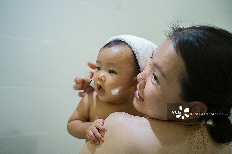 亚洲母亲抱着女儿在浴室里一起淋浴家庭生活图片素材