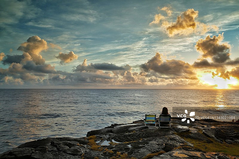 夏威夷下普纳海岸，一位妇女在太平洋上观看日出。图片素材