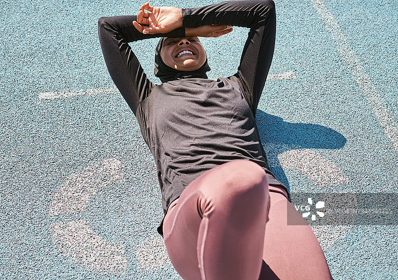 一个女人在跑道上休息训练的镜头图片素材