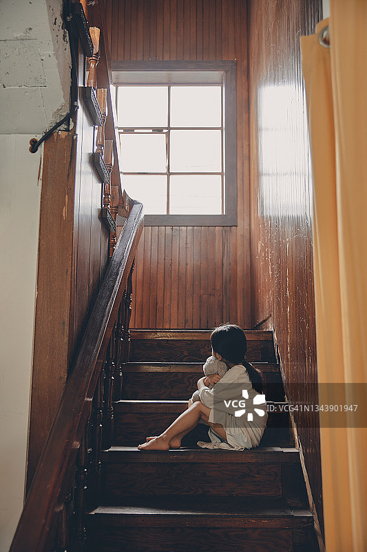 一个孩子独自坐在楼梯上图片素材