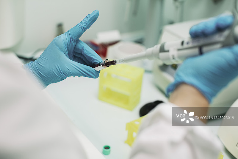 女性医学专家在实验室工作时使用移液管图片素材
