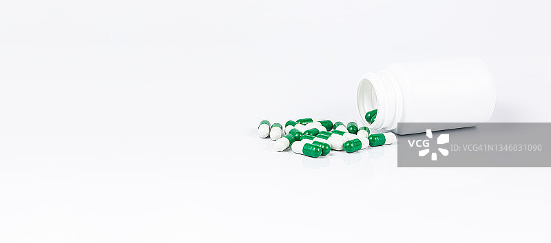 药丸和药瓶在白色背景，药丸溢出的药瓶隔离在白色。图片素材