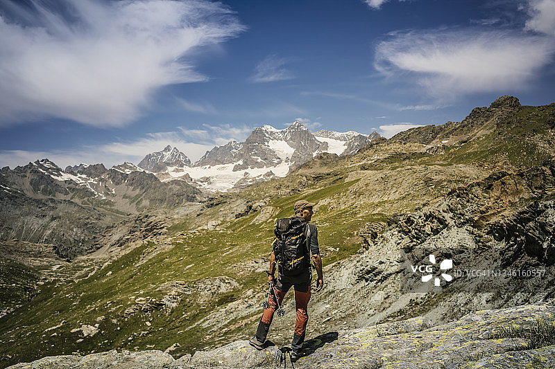 登山运动员站在山顶，在背景山脉图片素材
