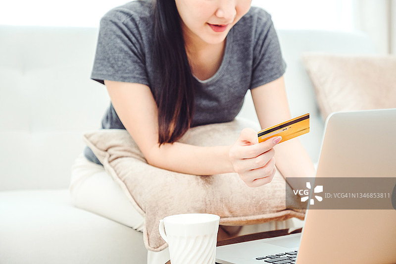 网上银行女性使用笔记本电脑和信用卡在家网上购物，Fintech和区块链概念图片素材
