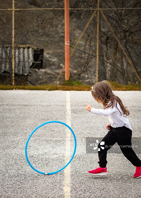 一个女孩在农村学校的篮球场图片素材