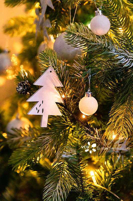 经典的圣诞装饰新年树。圣诞树有白色和银色的装饰，装饰玩具和球。现代古典风格室内设计公寓。平安夜在家图片素材
