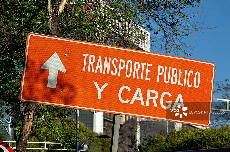 城市街道上写着“Transporte publico y carga”(公共交通和货物)的西班牙语路标图片素材