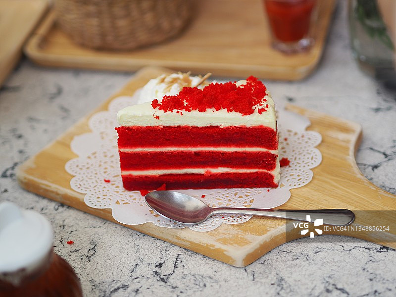 几块红丝绒价格蛋糕顶上的糖霜放在一个木托盘盘上贴着白纸旗，小吃味甜可口图片素材