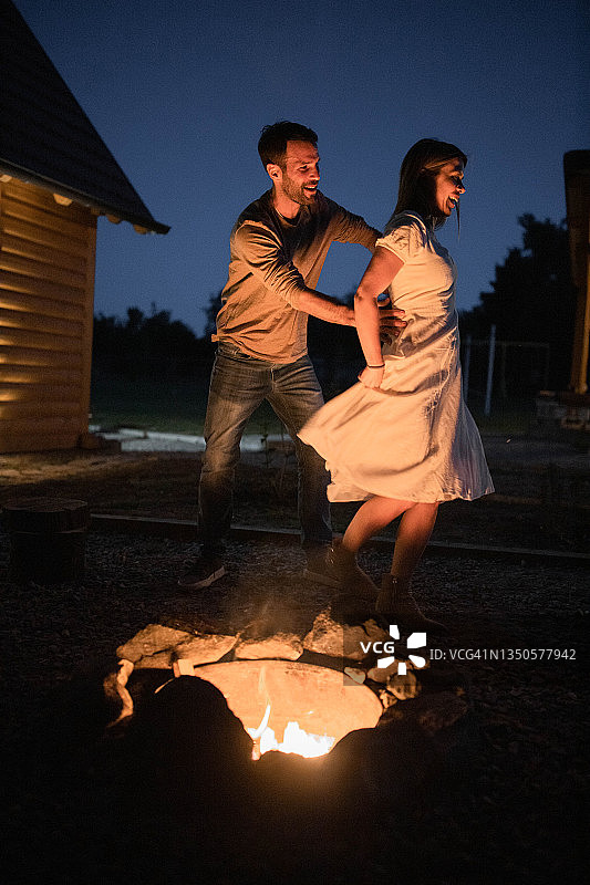 幸福的情侣在篝火旁度过浪漫之夜。图片素材