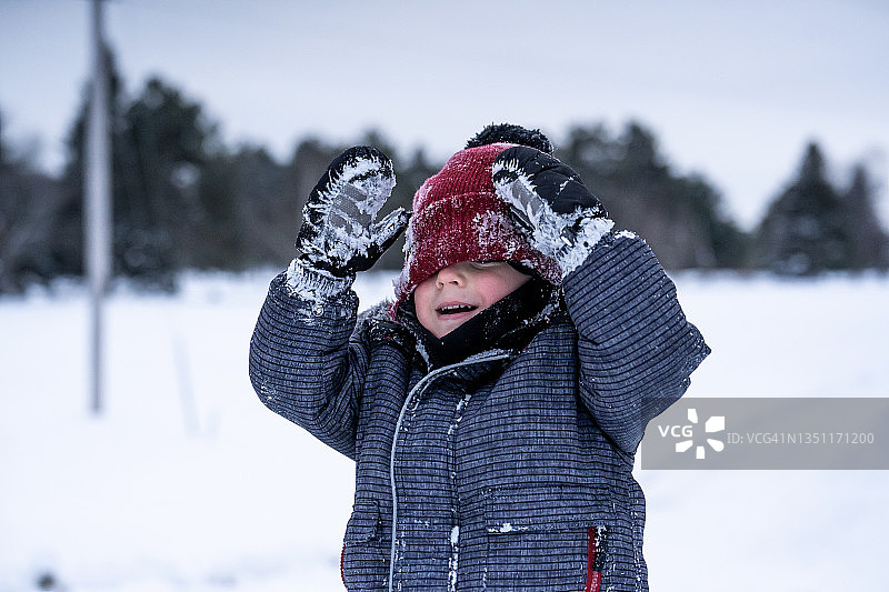 小男孩在雪中玩耍。图片素材