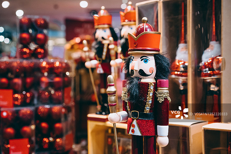 传统的木制胡桃夹子在零售店里陈列，搭配精选的圣诞装饰品和圣诞季的背景装饰。圣诞节倒计时。节日和庆典概念图片素材