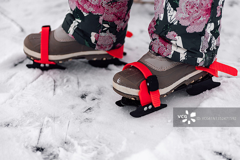 儿童溜冰鞋的特写镜头。孩子们脚上穿着暖暖的冬装，脚上系着孩子们的冰鞋，冬天多雪图片素材