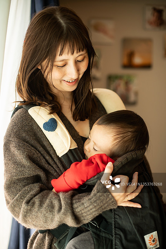 一位母亲把她的男婴放在她的怀里图片素材