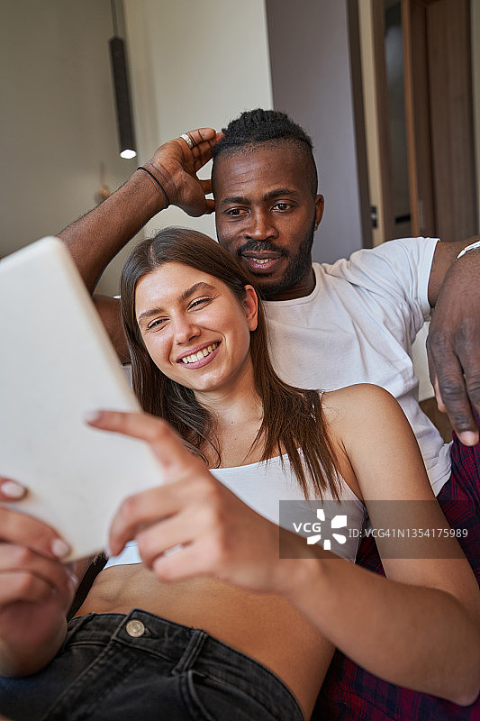 微笑的女人和专注的男人看着平板电脑图片素材