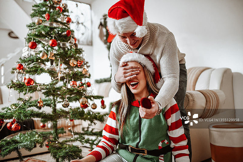圣诞树下给可爱女性的惊喜求婚时间图片素材