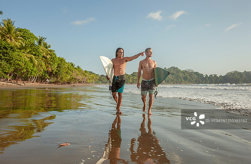 两个在海滩上玩冲浪板的朋友图片素材