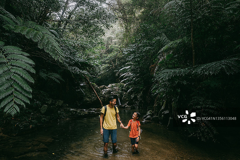 父亲和女儿在丛林河徒步旅行，冲绳，日本图片素材