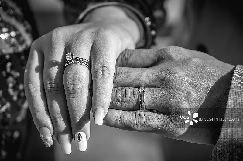新婚夫妇手上的戒指刚在婚礼后戴上，黑白摄影图片素材