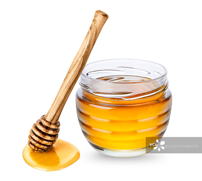 玻璃罐蜂蜜和木制蜂蜜勺白色背景图片素材