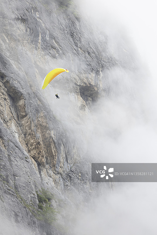 在瑞士山谷和瀑布的背景上滑翔图片素材