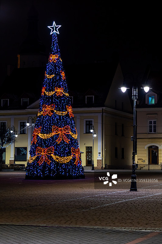 圣诞树矗立在城镇广场上的景象。图片素材