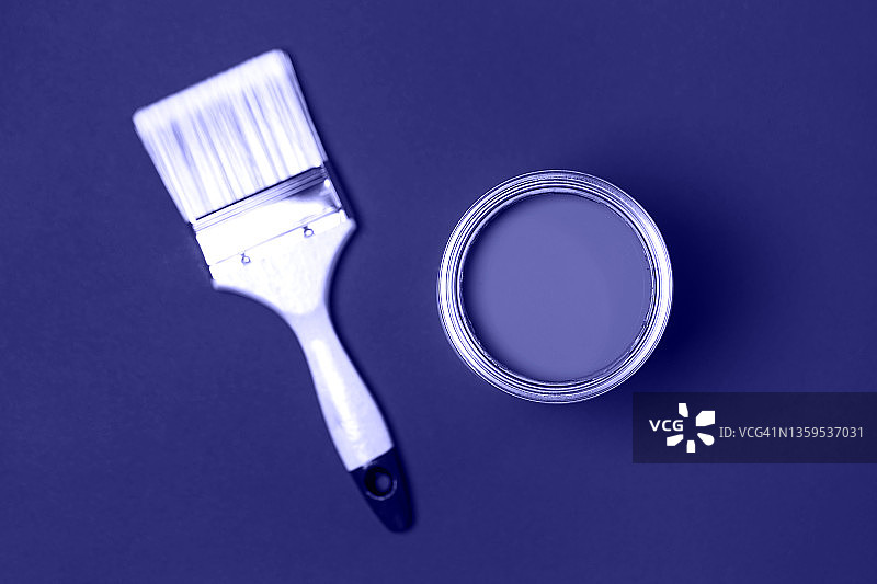 油漆刷和金属罐用紫色油漆用于紫色底色上的装修工程。平铺风格的微距摄影。展示了2022年的颜色。图片素材