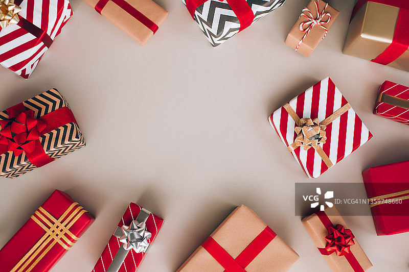 顶视图的圣诞节礼品盒和轻型花环形成框架上的灰色背景。庆祝新年的概念图片素材