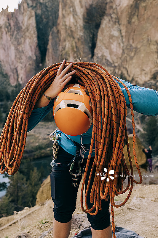 一名攀岩者将一根缠绕在肩上的绳索取下图片素材
