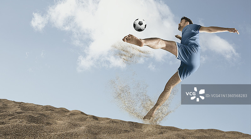 在一个阳光明媚的日子里，足球运动员们在沙滩上拼命地踢沙滩足球图片素材