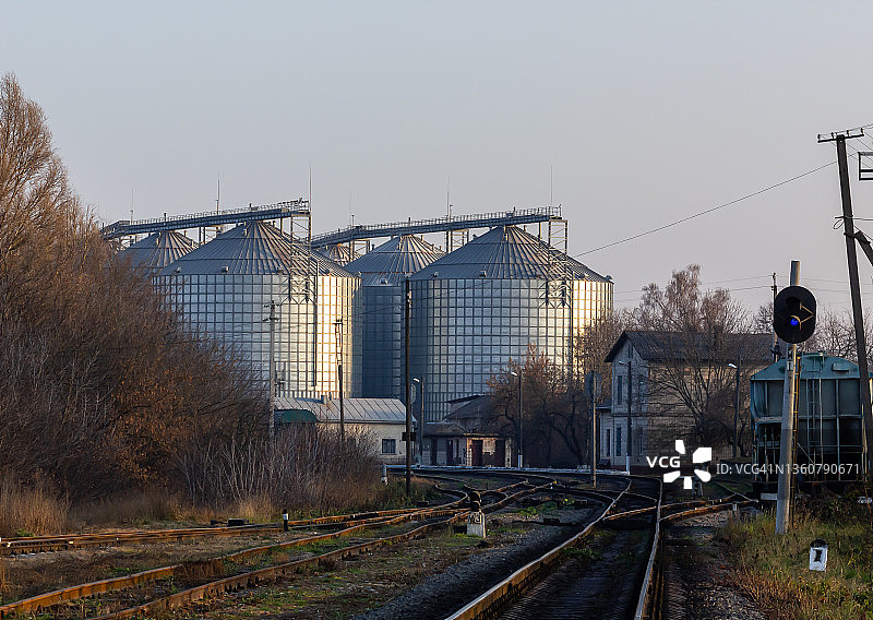 粮食加工厂用于储存和加工粮食作物的大型现代加工厂在阳光明媚的日子里看到的粮仓。大铁桶谷物。银筒仓在农业制造工厂用于加工和干燥图片素材