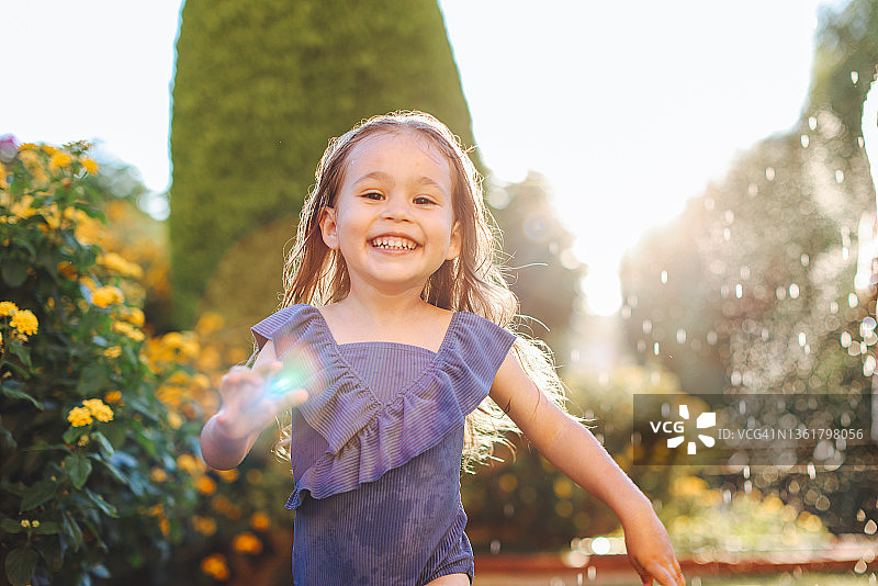 一个女孩的手谁收集蓝色的花在一个温暖的阳光灿烂的夏日草地上的花束。图片素材