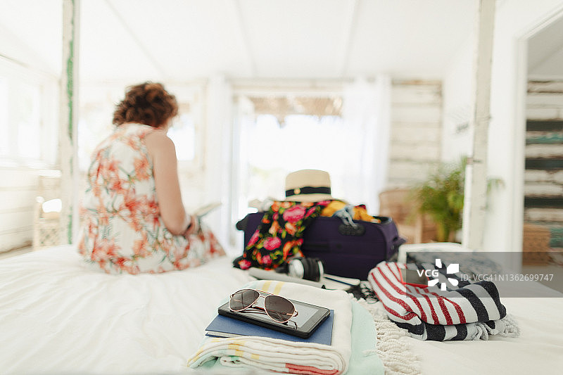 一个女人在海滨别墅的卧室里打开行李箱图片素材