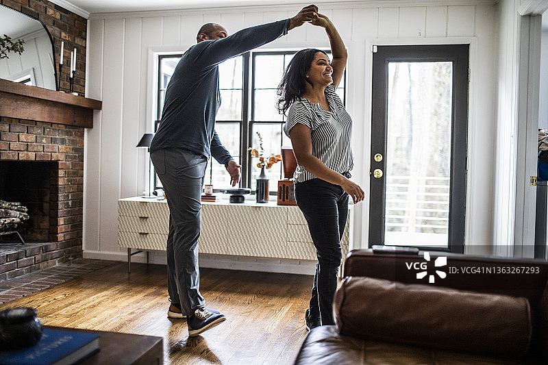 已婚夫妇在住宅客厅跳舞图片素材