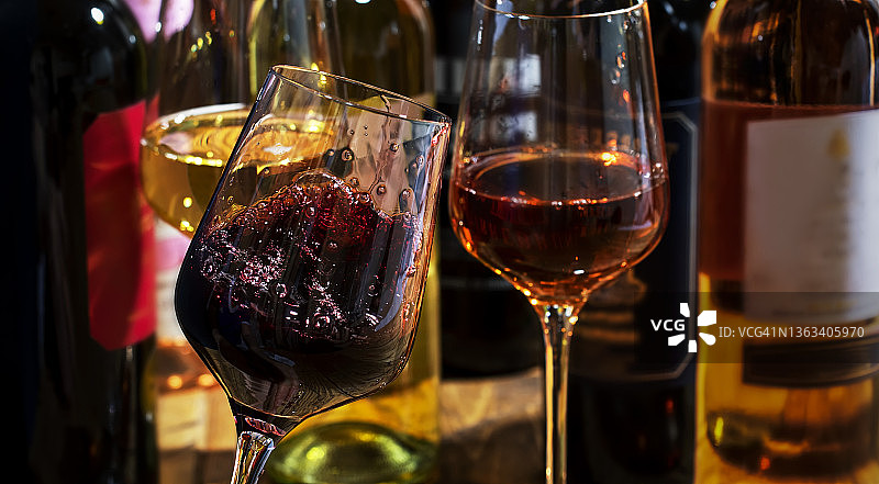 红色，白色和玫瑰葡萄酒在玻璃上木制的背景和收藏酒瓶，复制空间图片素材