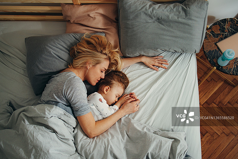 俯视图拍摄的母亲和孩子舒适地躺在他们的早晨图片素材