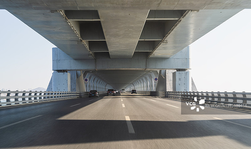在行驶中的汽车上拍摄的动态模糊的桥梁路面图片素材