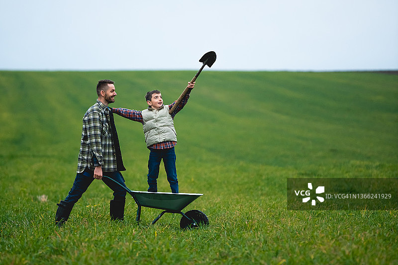 那个年轻的农民和他的儿子在地里玩得很开心图片素材