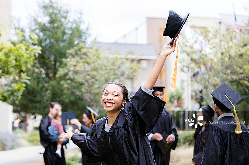 女毕业生在空中高举帽子微笑图片素材