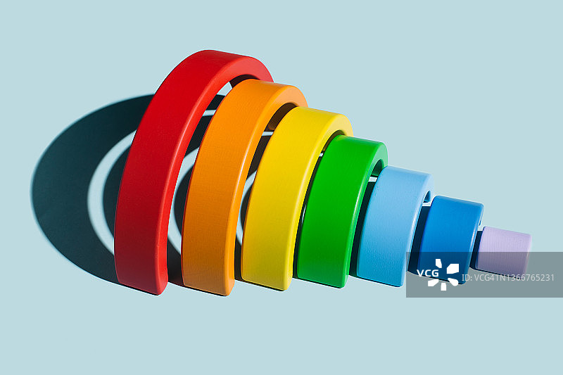 蓝色背景上的木制彩虹玩具图片素材