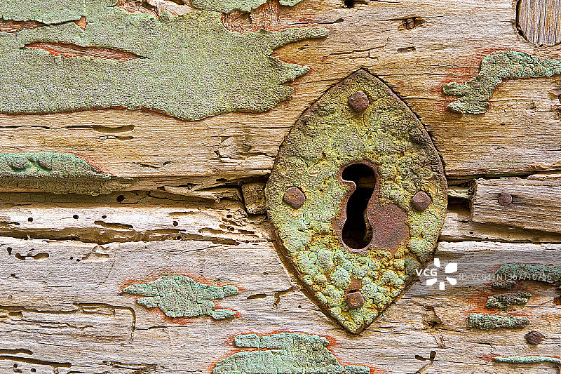 旧木门上生锈的金属锁孔图片素材