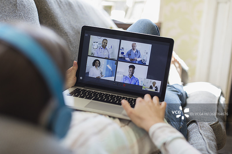 十几岁的女孩视频聊天与医生在笔记本电脑屏幕图片素材