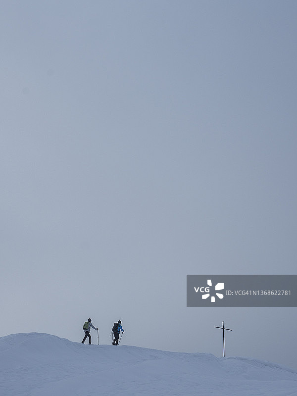 攀登者在积雪的山脊上。图片素材