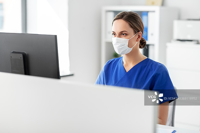 医生或护士戴着口罩在医院使用电脑图片素材
