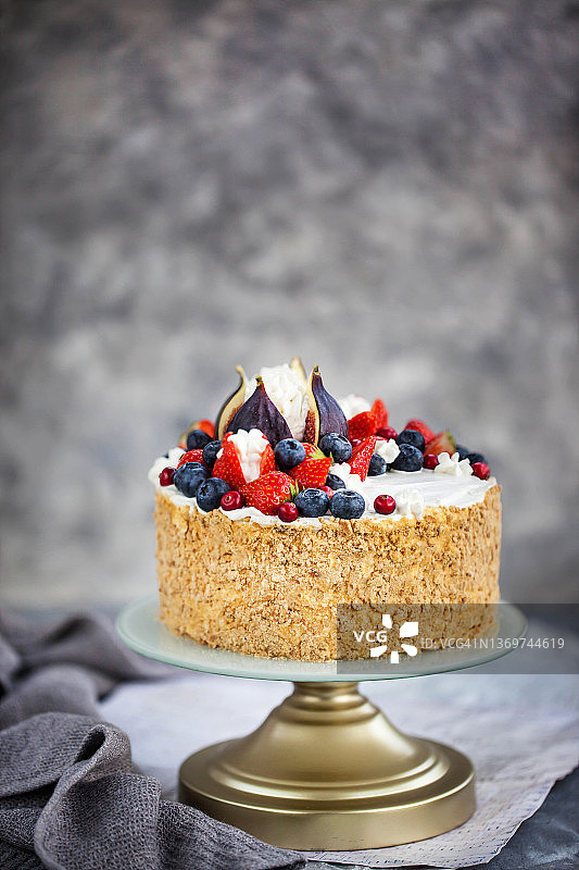 自制蜂蜜蛋糕，用新鲜无花果、草莓和蓝莓装饰的多层奶油蛋糕图片素材