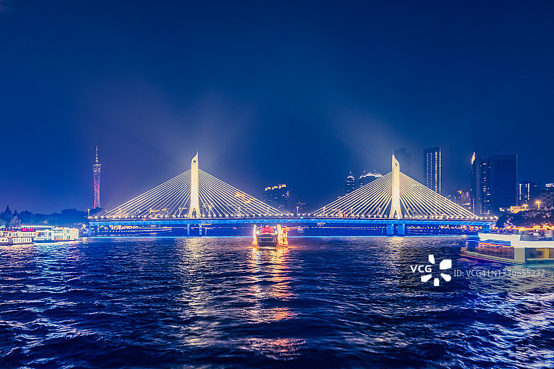 横跨珠江的吊桥，珠江上的游船，广州塔在远处图片素材