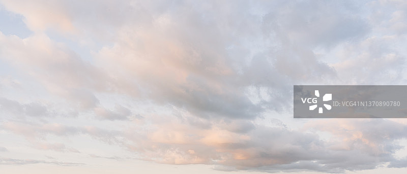 日落时，粉红色的云彩映衬着蓝色的天空图片素材