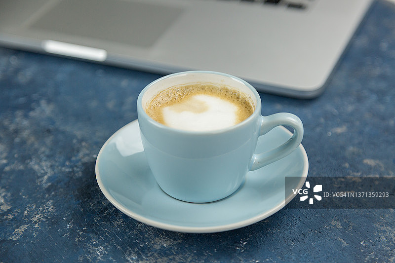 一杯咖啡对着笔记本电脑图片素材