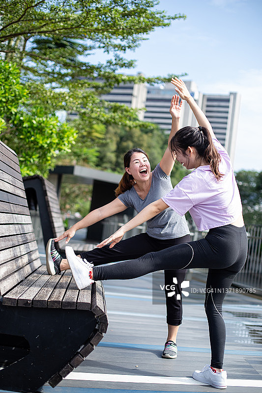 两个女人在锻炼后享受在公园里伸展和热身的乐趣图片素材