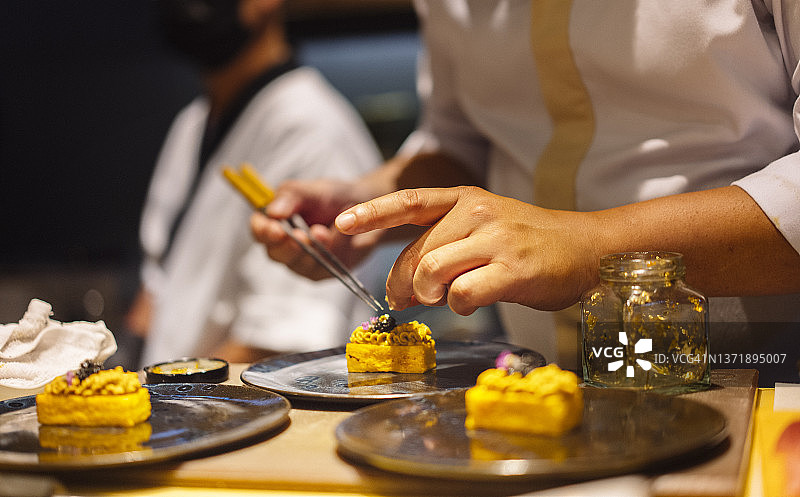 近距离的日本寿司厨师的手使用火炬燃烧金枪鱼寿司的客户omakase课程图片素材